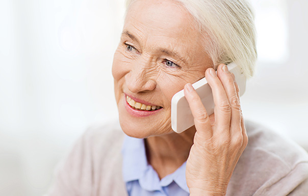 Femme souriante au téléphone avec l'équipe ABDF